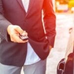 A man in suit and tie holding a cell phone.