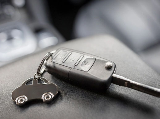 A car key with a keychain in the shape of a car.