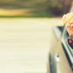 A person holding their car keys out of the window.